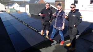 Liz Chilcott of Chilcotts auctioneers ‘cutting the ribbon’ on a solar PV installation with Mark Fowler and Lewis Vaile of installers L and M Renewables